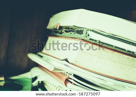 Stack of books background. many books piles. High books stack on wooden shelf background. Vintage retro picture style.