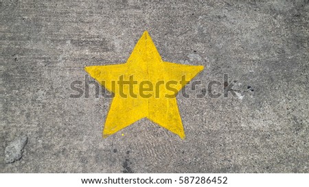 Yellow painting star on concrete texture background