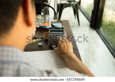 Businessman working on calculator financial calculating budget numbers
