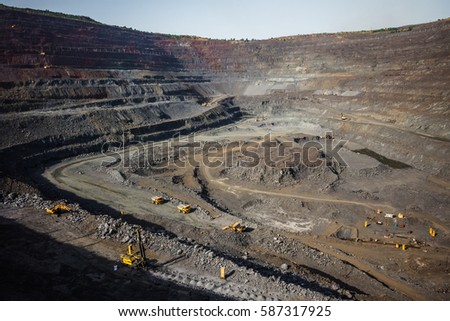 Iron ore quarry. Mining machinery Royalty-Free Stock Photo #587317925