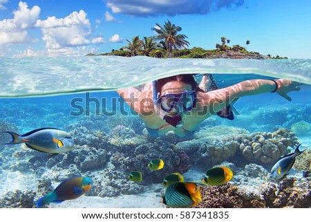 Young woman at snorkeling in the tropical water Royalty-Free Stock Photo #587341835