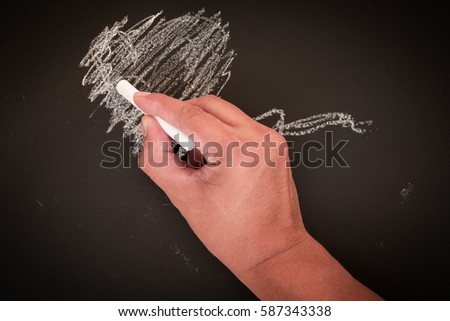 hand to draw something on blackboard with chalk