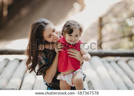 Cheerful mother and daighter sit on the roof of an old house Royalty-Free Stock Photo #587367578