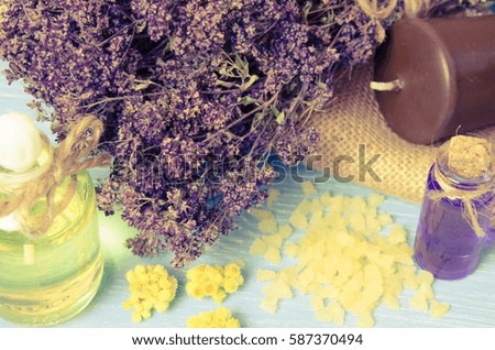 oil for aromatherapy homemade with dry flowers on wooden background. Toned photo
