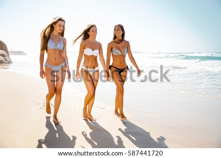Beautiful girls enjoying the summer giving a walk on the beach 