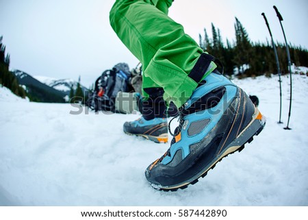 hiker with backpack on the trail in the Carpathians mountains at winter. picture of hiker taken on wide angle from low point