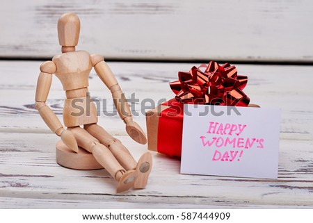 Wooden manikin and present box. How to impress woman.