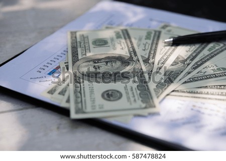 Close up of Business workplace with money on wooden table.