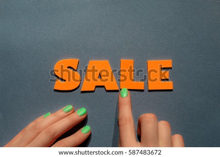 Hands with Green Nails Making the "Sale" the "Sale" Word with Grey Background