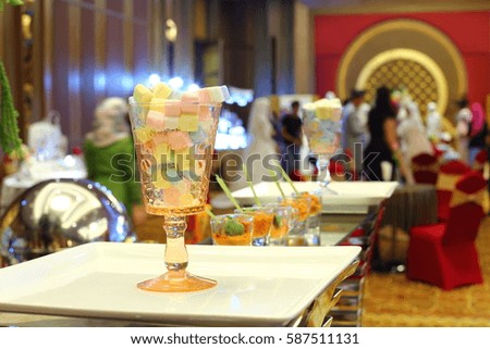 Pastel Sweet Marshmallow in cup Glass on Square white plate, people in wedding fair, cocktail, meetting background