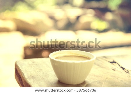 Coffee mug on wooden table outdoor background- Vintage effect style pictures