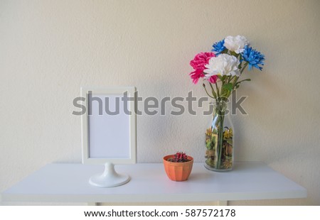 photo White Frame on a wooden and Flowers in jar , cactus on wall background .