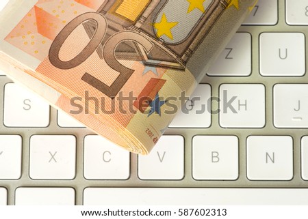 Euro banknotes and a computer