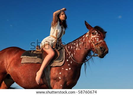Beautiful young woman posing with a brown horse.