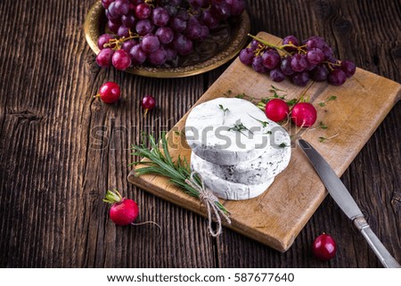 Cheese with white mold. Camembert or brie type. Radish, rosemary and grape. Healthy breakfast.