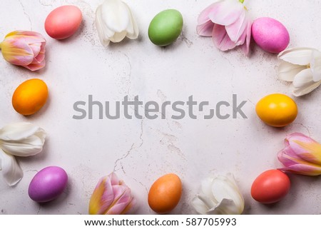 Colorful tulips and Easter eggs on old background. Festive  Easter concept with copy space. Flat lay