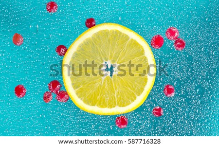 abstract picture of a cocktail with orange slices, banana, Apple and cranberries with the water bubbles on the background of the turquoise and blue colors