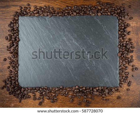 Coffee beans around a slate board