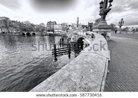Bridge in Amsterdam with typical local architecture. Embankment in the historical center of Amsterdam in the Netherlands. Black and white picture