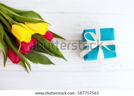 Flowers and gift. Top view. Concept of holiday, birthday, Easter, March 8.