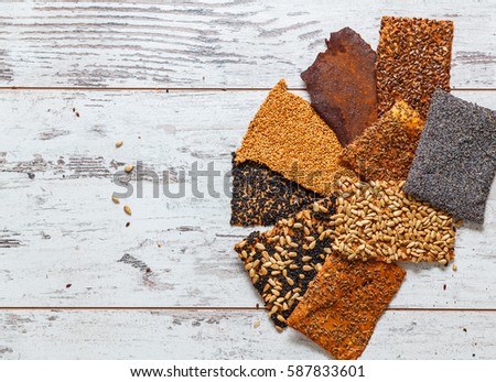 Various kinds of baked thin healthy seed crackers (sunflower, sesame, poppy, aniseed, linseed, black cumin, cinnamon). photo with shallow depth of field
