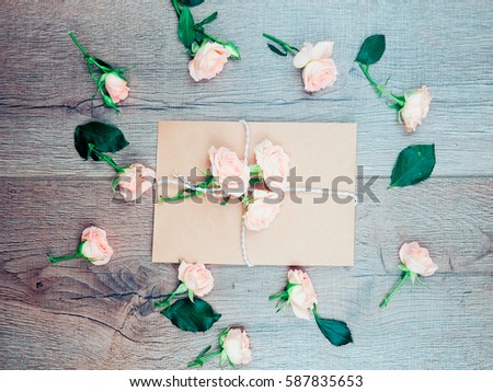 the old style envelope, Kraft paper on wooden background, top view with roses, message, space for text