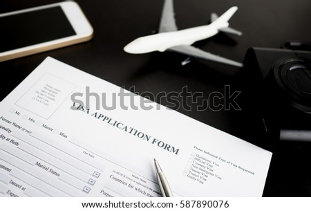 Filling travel Visa application immigration 
form for vacation and business travel. with blank VISA application form ready to fill in for immigrant arrival. Royalty-Free Stock Photo #587890076