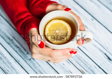 Woman holding a cup with tea