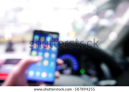 Picture blurred  for background abstract and can be illustration to article of Hand using a smartphone while driving a car