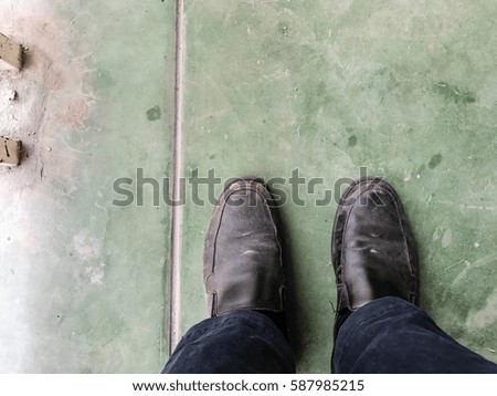 Man wearing black shoes on green concrete ground