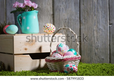Easter eggs painted on a wooden background of boards on green grass.