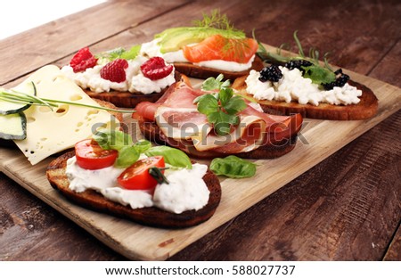 Bread Brushetta or authentic traditional spanish tapas set for lunch table. Sharing antipasti on party or summer picnic time over wooden rustic background.