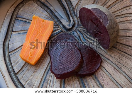 Beets and carrots cooked on a textured cutting Board 