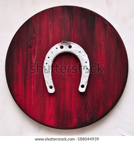 Silver horseshoe on painted red wood background