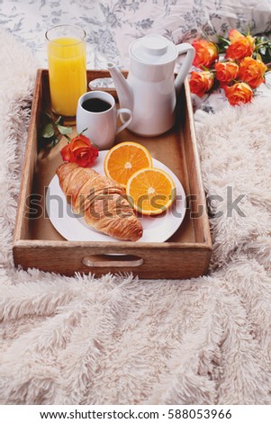 breakfast in bed with coffee croissant orange and juice