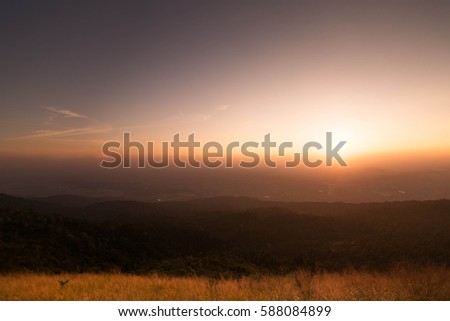A mountain scape view with clouds and sun rays.