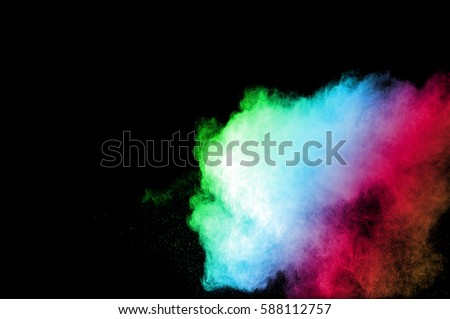 Abstract art colored powder on black background. Frozen abstract movement of dust explosion multiple colors on black background. Stop the movement of multicolored powder on dark background.