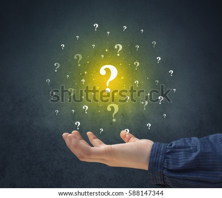 Yellow question marks hovering over young hand