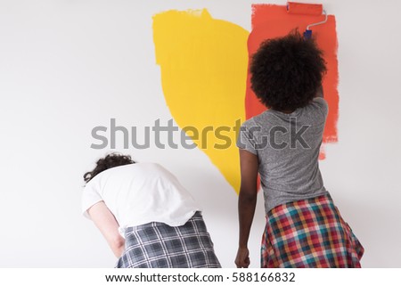 happy young multiethnic couple painting interior wall of new house