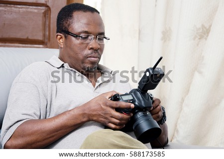 After his photo shoot; this photographer looks at his pictures to appreciate