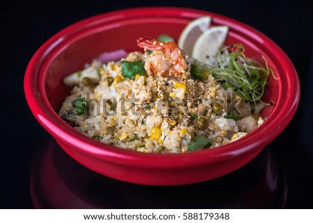 Healthy food in the Japanese style. Seafood with a red plate on a black background.