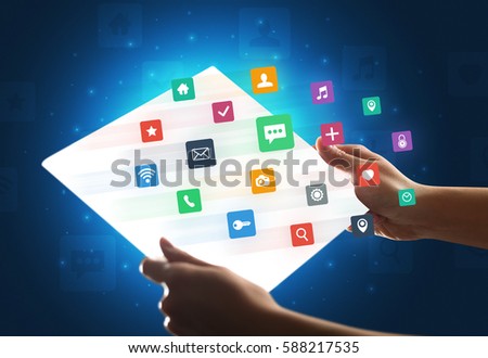 Young female hand holding a tablet with colorful mixed media icons