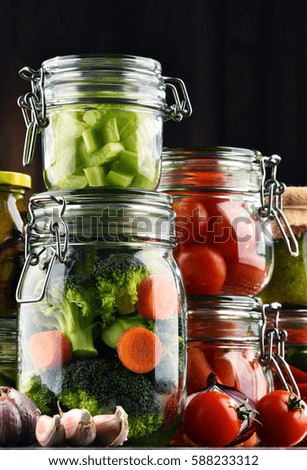 Jars with marinated food and organic raw vegetables.