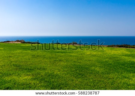 Background green lawn, sea, sky. Royalty-Free Stock Photo #588238787