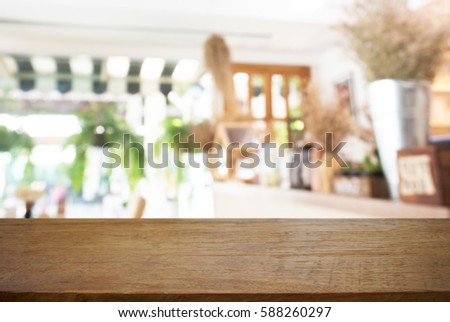 Empty wooden table in front of abstract blurred background of coffee shop. can be used for display or montage your products.Mock up for display of product