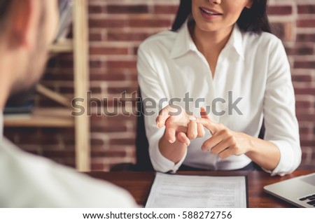 Beautiful female employer in suit is conducting a job interview while sitting in her office Royalty-Free Stock Photo #588272756