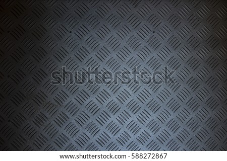 Industrial wallpaper of functional anti-slip metal tread plate in grey silver color and rough raised surface pattern. Creative lighting macro photography of construction for catwalks, stairs, walkway. Royalty-Free Stock Photo #588272867