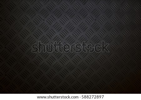 Industrial wallpaper of functional anti-slip metal tread plate in grey silver color and rough raised surface pattern. Creative lighting macro photography of construction for catwalks, stairs, walkway. Royalty-Free Stock Photo #588272897