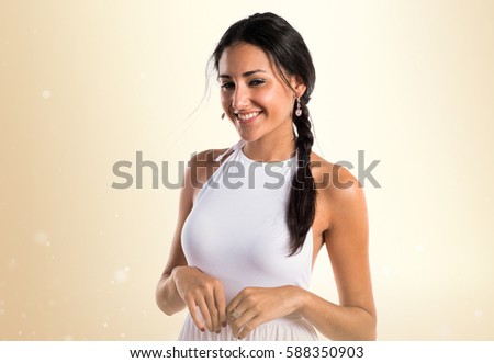 Pretty model girl posing in studio on ocher background