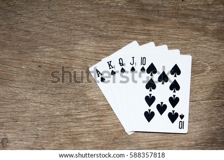 Five card of black spade royal straight flush on wooden background